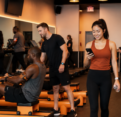 A woman looking at her phone walking into a fitness class.